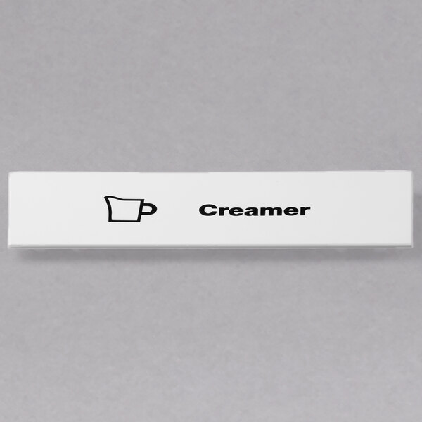 A white rectangular ID clip with black text that says "creamer"