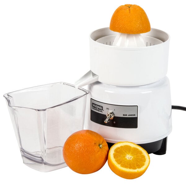 A Waring citrus juicer with an orange next to it.