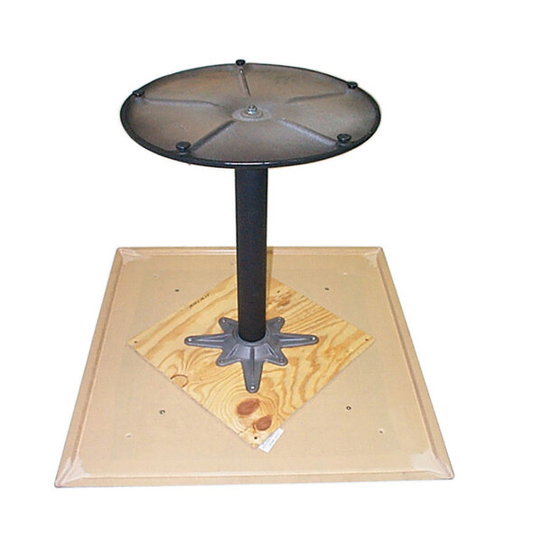 A round table with a metal pole on a wooden surface with a Grosfillex 20" square natural wood mounting plate attached.