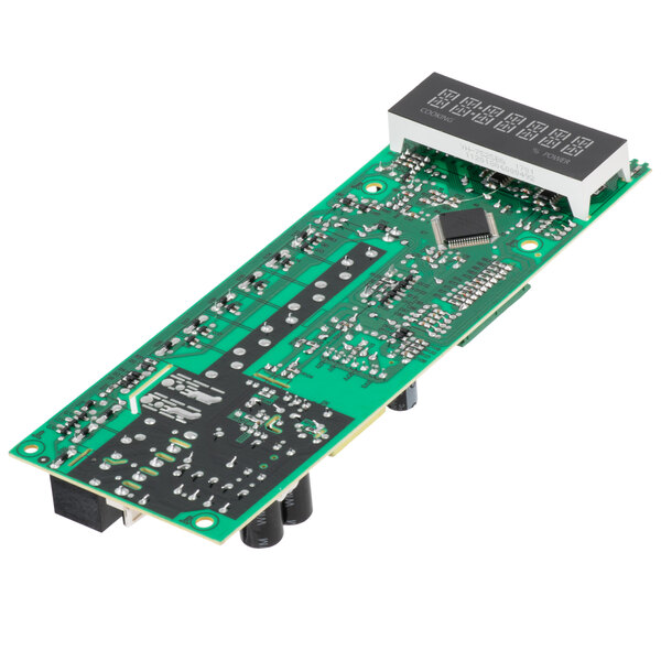 A close-up of a green circuit board for a Solwave microwave with black and grey chips.
