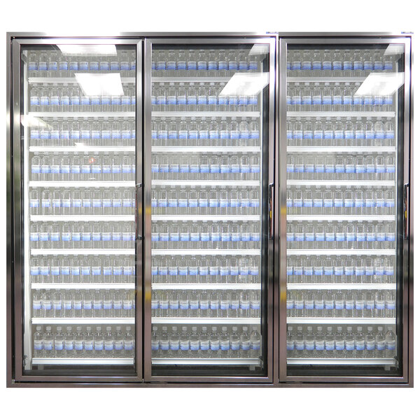 Three Styleline Classic Plus glass walk-in cooler doors with shelving filled with blue bottles of water.