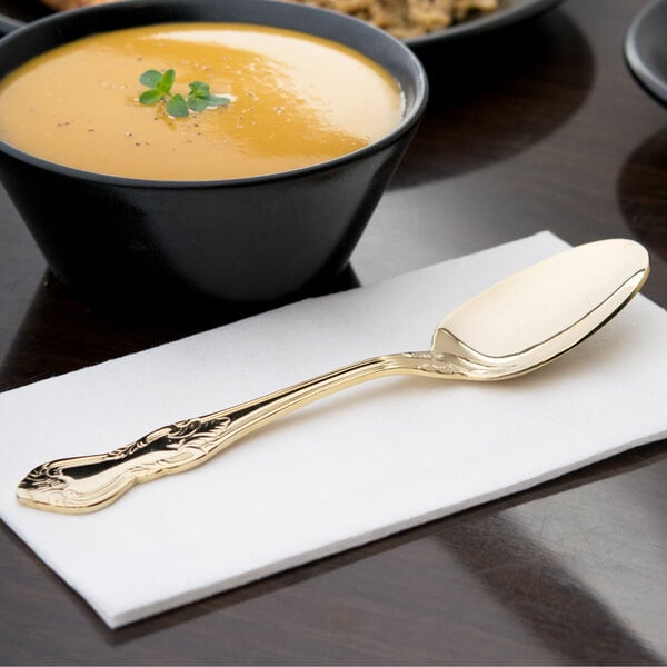 A 10 Strawberry Street Crown Royal stainless steel dinner spoon with a gold plated handle on a napkin.