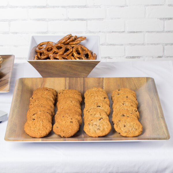A Tablecraft acacia wood melamine tray of cookies and pretzels on a table.