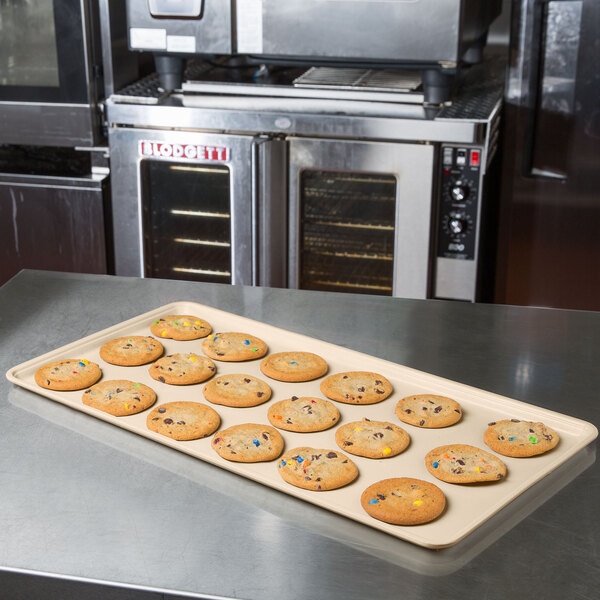 A beige MFG Tray Supreme Display Tray holding cookies with colorful sprinkles on a counter.