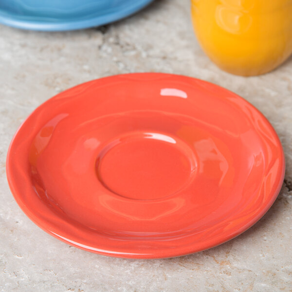 A close up of a orange Libbey Cantina saucer.