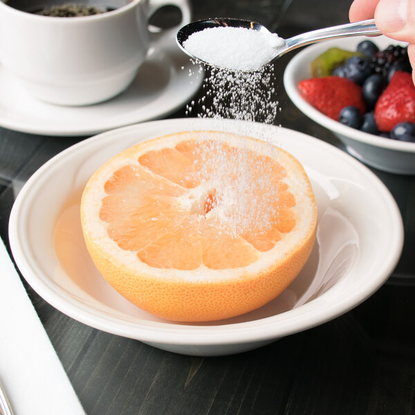 A close-up of a Libbey ivory porcelain grapefruit bowl filled with fruit.