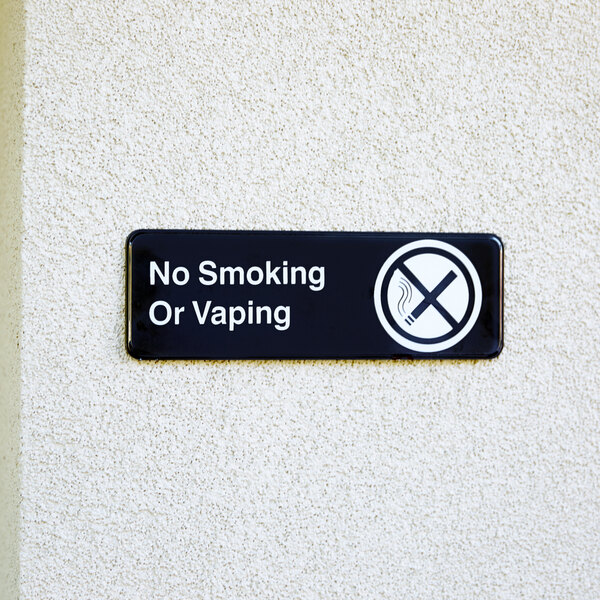 A Tablecraft black and white sign on a wall that says "No Smoking or Vaping"