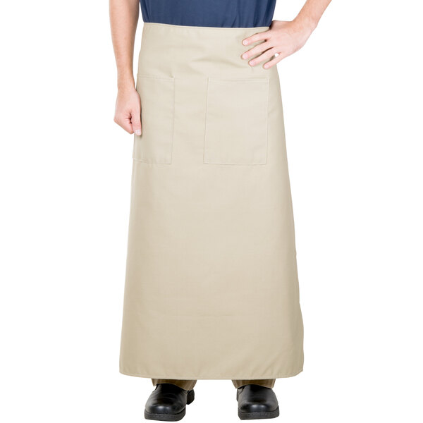 A man wearing a beige Intedge bistro apron with pockets.
