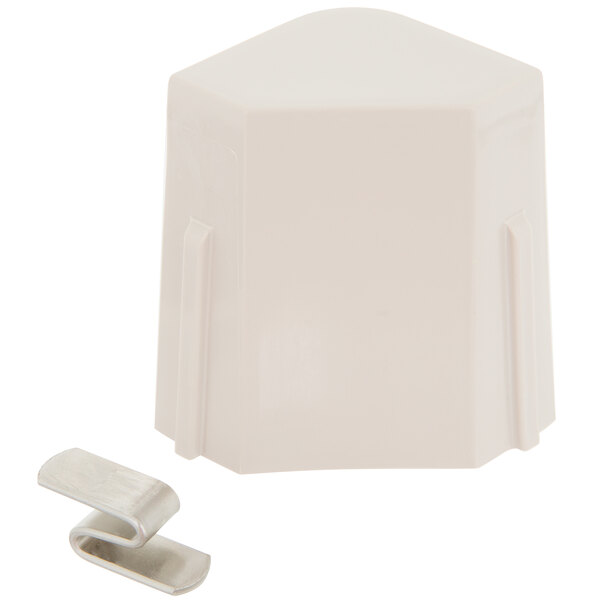 A white plastic object with a metal clip and pointy top.