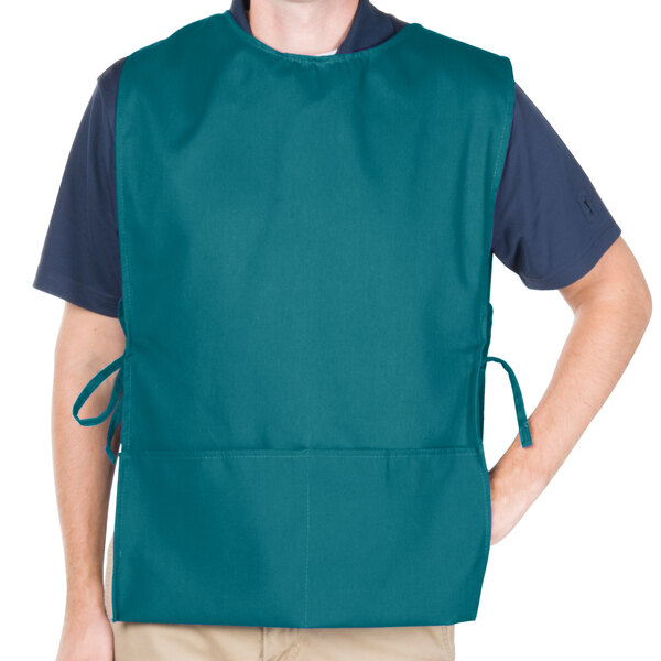 A man wearing a teal Intedge cobbler apron with pockets.