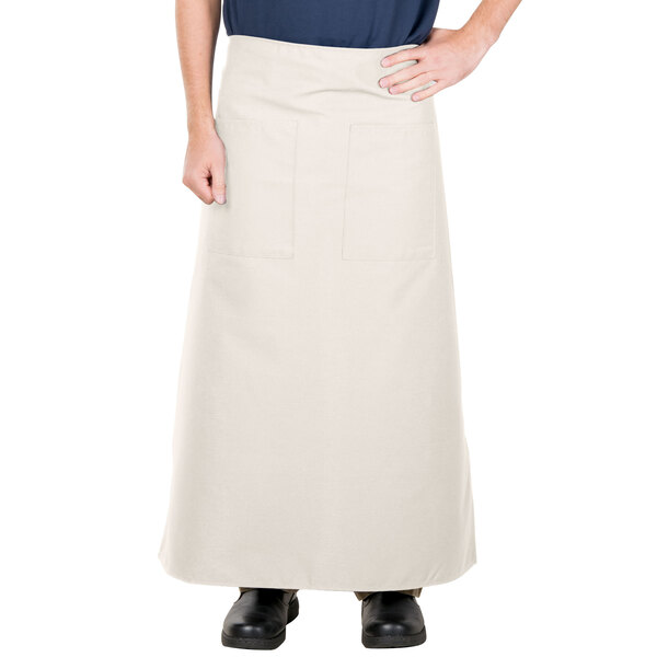 A person wearing an ivory Intedge bistro apron with 2 pockets.