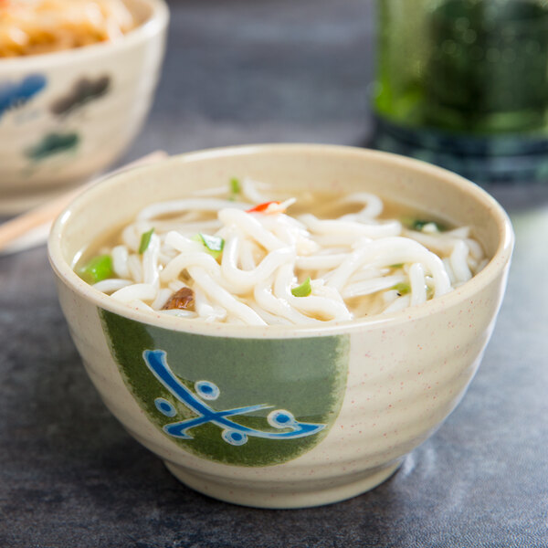A Japanese traditional melamine bowl with a blue design filled with noodle soup.