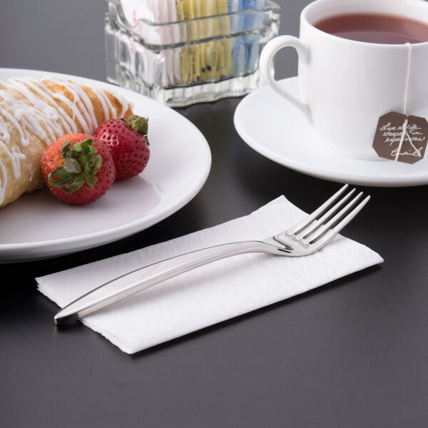 A stainless steel Libbey dessert fork on a napkin.