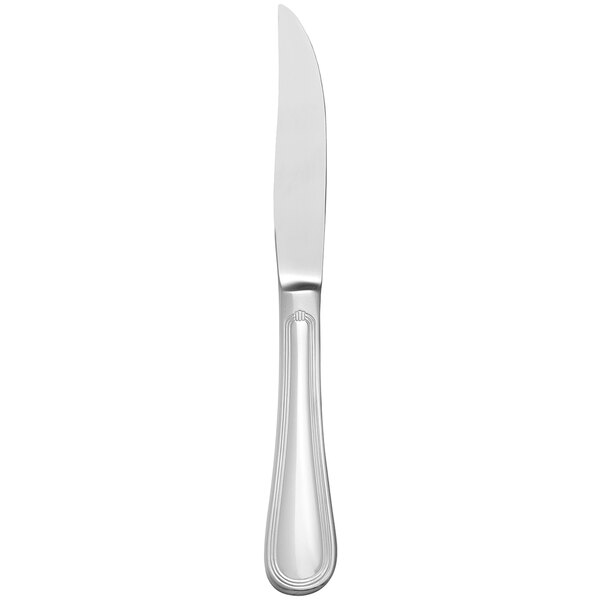 A close up of a Libbey steak knife with a solid stainless steel handle.