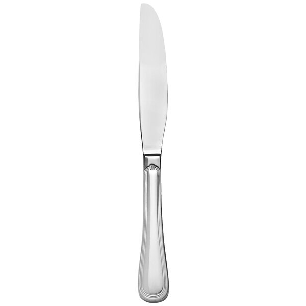 A silver stainless steel dinner knife with a white solid handle.