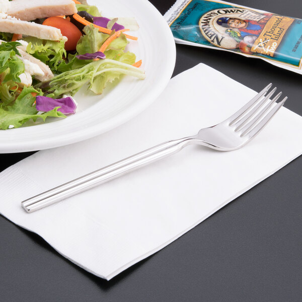 A Libbey stainless steel salad fork on a plate of salad with chicken and vegetables.