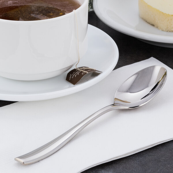 A cup of tea with a Libbey stainless steel teaspoon on a napkin.