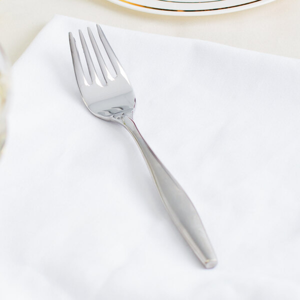 A Libbey stainless steel dessert fork on a white napkin.