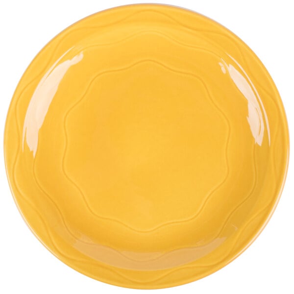A Libbey Cantina saffron porcelain plate with a wavy rim.