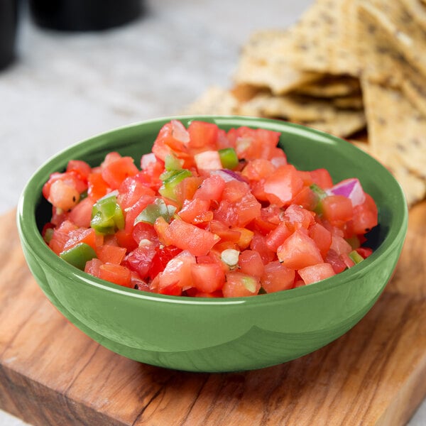 A bowl of salsa and chips on a table.