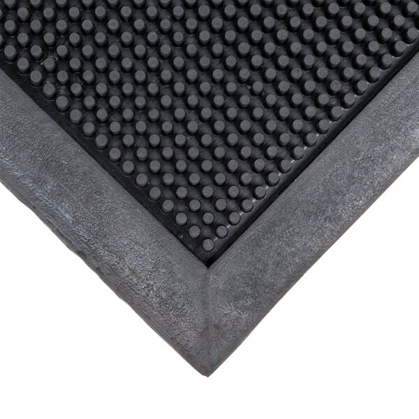 A close-up of a black rubber Cactus Mat with holes in it.