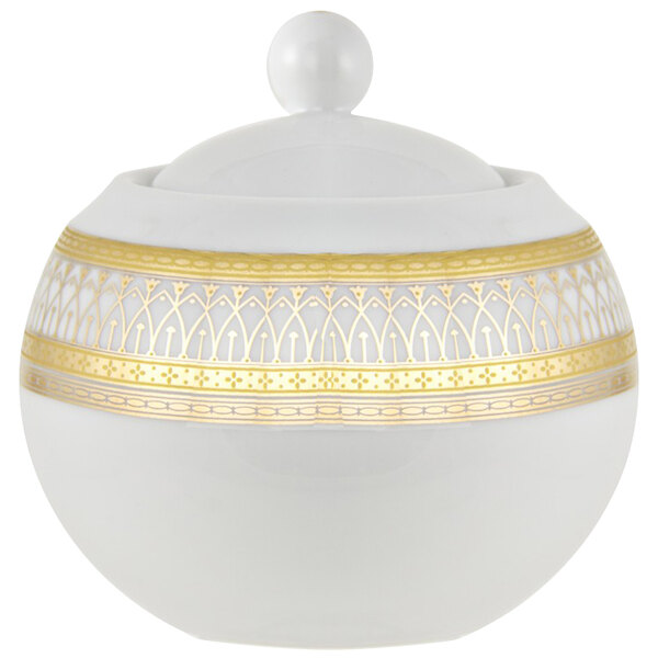 A white porcelain sugar bowl with a gold lid and patterned border.