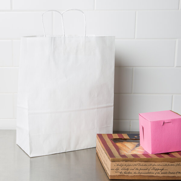 A white Duro shopping bag on a table with a pink box inside.