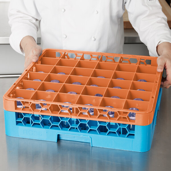 A person holding a tray with orange and blue Carlisle plastic containers.
