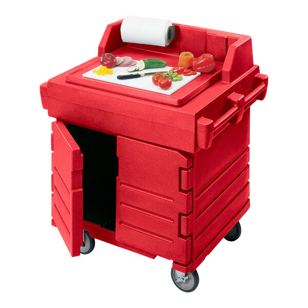 A red Cambro CamKiosk food preparation cart with a cutting board and vegetables on it.