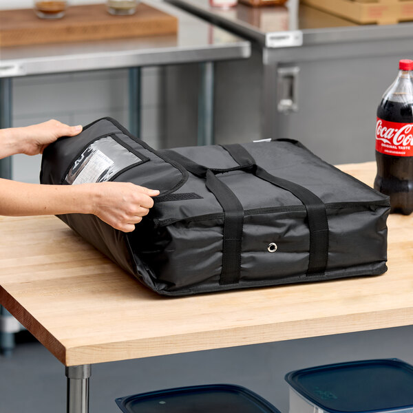 A black soft-sided insulated pizza delivery bag made of heavy-duty nylon, designed to hold up to two 16-inch pizza boxes or one 18-inch pizza box.