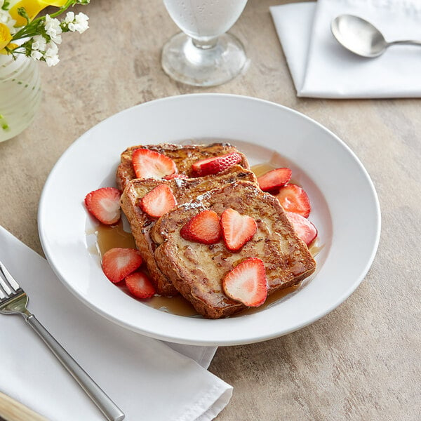A plate of french toast with strawberries on a white Acopa stoneware plate.