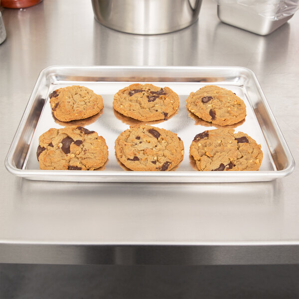 A Vollrath Wear-Ever bun pan filled with cookies on a table.