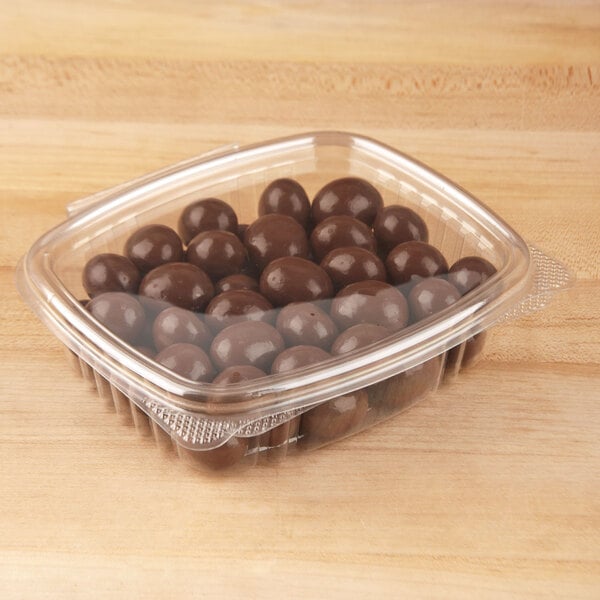 A Genpak clear plastic deli container filled with chocolate candies.