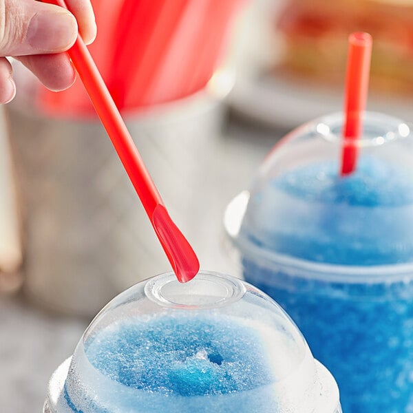 A hand holding a red Choice Super Jumbo spoon straw over a blue beverage.