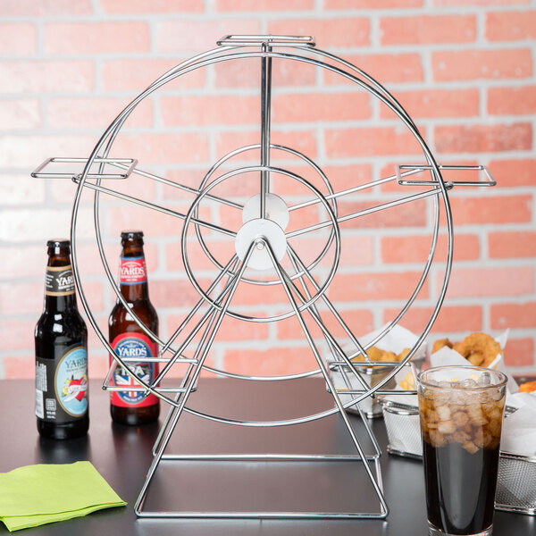 A Clipper Mill chrome ferris wheel rack holding beer and snacks on a table.