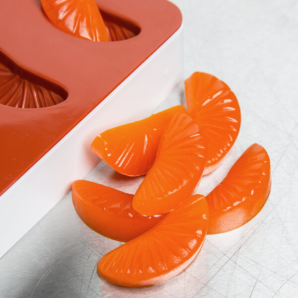 A Martellato red silicone mold tray with tangerine slices.