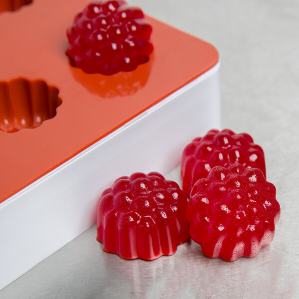 A Martellato red silicone mold with 24 raspberry-shaped compartments.