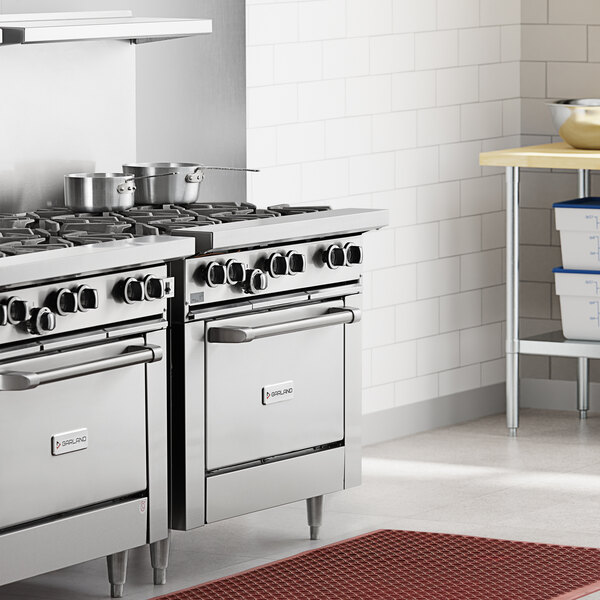 A Garland 6 burner range with oven in a professional kitchen.
