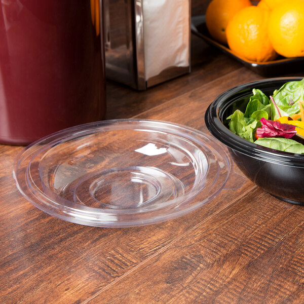 A clear plastic Fineline dome lid on a bowl of salad.