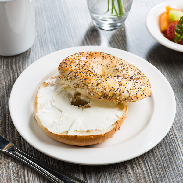 A bagel with cream cheese on a white Libbey Slenda porcelain plate.