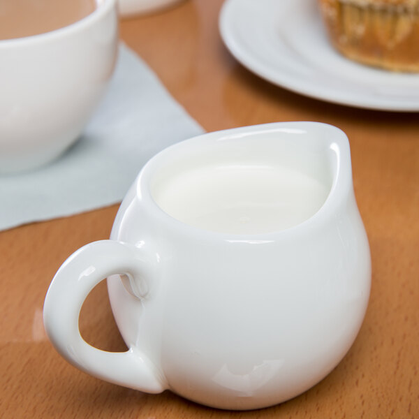 A white Libbey porcelain creamer with a handle and lid.