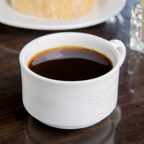 A white Reserve by Libbey Royal Rideau porcelain cup of coffee on a table.
