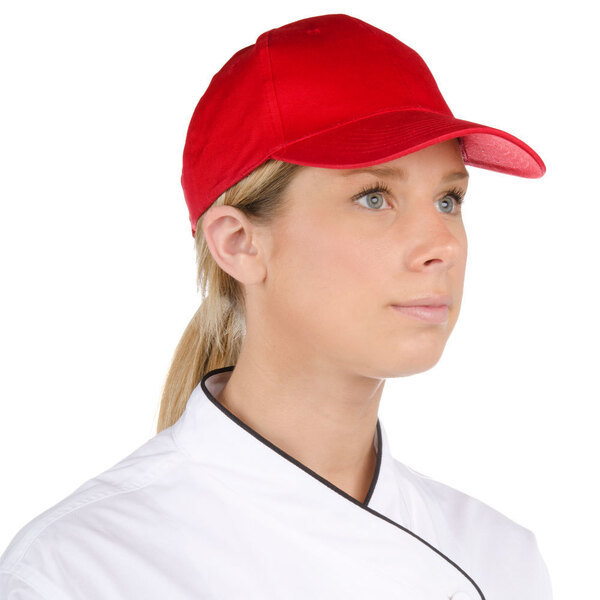 A chef wearing a white uniform and red Choice 6-panel cap.