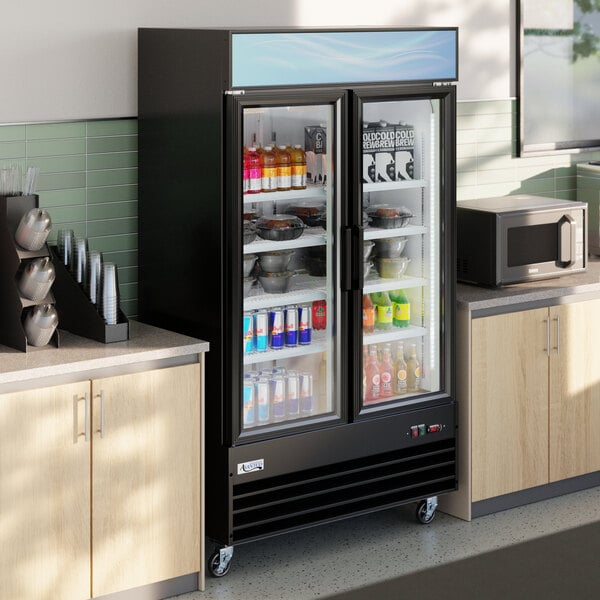 A black glass door merchandiser refrigerator with LED lighting, stocked with beverages and food items.