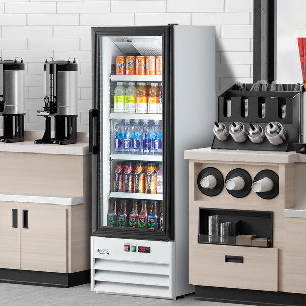 A white swing glass door merchandiser refrigerator with LED lighting, stocked with assorted beverages.