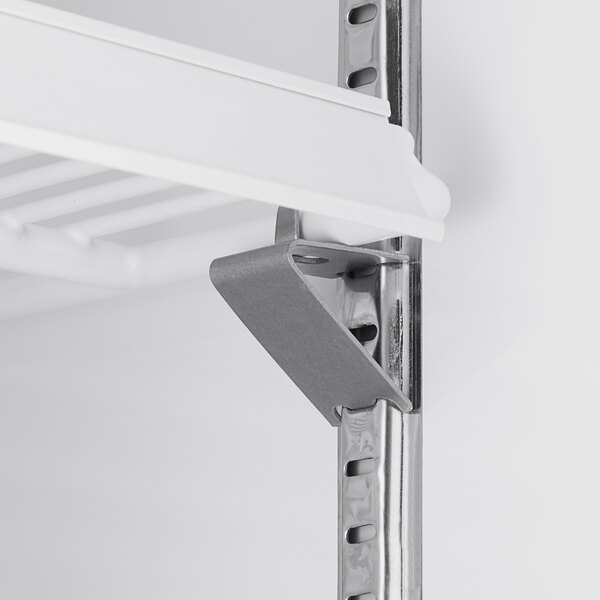 A close-up view of a metal shelf bracket supporting a white wire shelf inside a glass door merchandiser refrigerator.