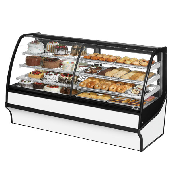 A True refrigerated bakery display case with different types of pastries on a curved glass counter.