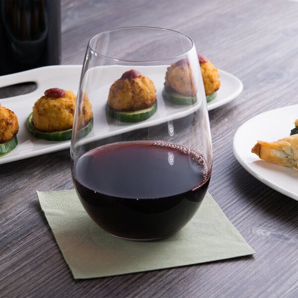 A Reserve by Libbey wine glass on a table with food on it.
