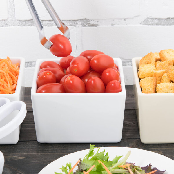 A white Tablecraft straight sided bowl filled with salad and tomatoes.