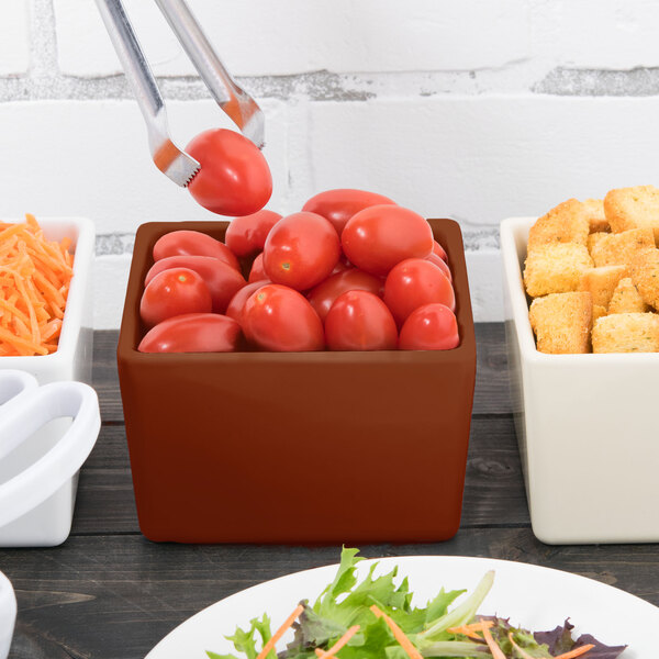 A brown Tablecraft straight sided bowl filled with tomatoes and croutons on a table.